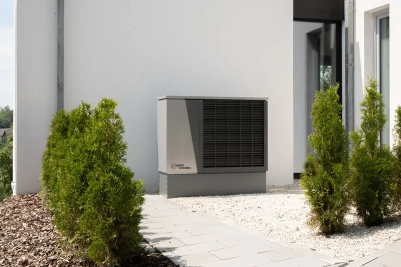 Wärmepumpe im Garten neben dem Wohngebäude